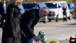 US President Joe Biden and first lady Jill Biden lay flowers at Schemengees Bar & Grille, one of the sites of last week's mass shooting, Nov. 3, 2023, in Lewiston, Maine. 