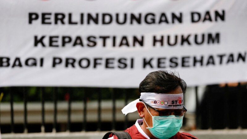 Seorang petugas kesehatan ikut serta dalam protes menentang RUU Kesehatan yang baru di luar gedung DPR RI di Jakarta, 5 Juni 2023. (REUTERS/Ajeng Dinar Ulfiana)