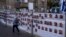 A man passes by a fence with photographs of hostages, mostly Israeli civilians who were abducted during the Oct. 7, unprecedented Hamas attack on Israel, in Ramat Gan, Israel, Nov. 22, 2023.