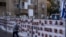 A man passes by a fence with photographs of hostages, mostly Israeli civilians who were abducted during the Oct. 7, unprecedented Hamas attack on Israel, in Ramat Gan, Israel, Nov. 22, 2023.
