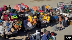 Afghan refugees sit beside their belongings at a registration center, upon their arrival from Pakistan near the Afghanistan-Pakistan border in the Spin Boldak district of Kandahar province, Nov. 20, 2023.