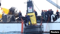 Philippine Coast Guard members place a buoy in a part of the South China Sea over which Manila claims sovereignty, in this handout image obtained May 15, 2023. (Philippine Coast Guard via Reuters). Staking its own claims, China has since responded in kind.