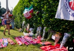 A woman brings flowers outside Silvio Berlusconi's residence in Arcore, near Milan, June 12, 2023.