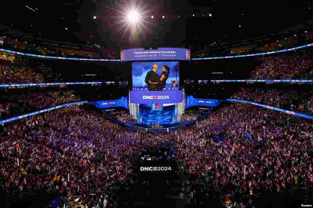 Former U.S. first lady Michelle Obama embraces her husband, former U.S. President Barack Obama, on stage before his speech during Day 2 of the Democratic National Convention (DNC) in Chicago, Illinois, Aug. 20, 2024. 