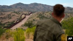 FILE - Border patrol agent Pete Bidegain looks from a hilltop on the U.S. side of the U.S.-Mexico border in Nogales, Arizona, June 25, 2024. (AP Photo/Jae C. Hong, Pool)