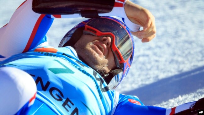 FILE - France's Alexis Pinturault lies on the snow after crashing during an alpine ski, men's World Cup super-G race, in Wengen, Switzerland, Jan. 12, 2024.