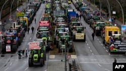 Tractors and trucks stand in a street during a protest of farmers and truck drivers, Jan. 15, 2024 in Berlin, Germany. 