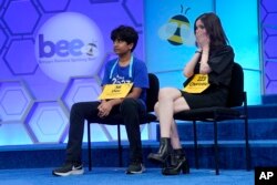 The final two contestants, Dev Shah, 14, from Largo, Fla., and Charlotte Walsh, 14, from Arlington, Va., sits on stage during a break of the finals of the Scripps National Spelling Bee, Thursday, June 1, 2023, in Oxon Hill, Md.