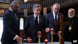U.S. Secretary of State Antony Blinken, second from left, participates in a World Refugee Day event with British Foreign Secretary James Cleverly, left, at Ukrainian Catholic Cathedral in London, June 20, 2023.