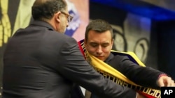 National Assembly President Henry Kronfle places the presidential sash on President Daniel Noboa after he was sworn in as the country's new president, during his inauguration ceremony at the National Assembly, in Quito, Ecuador, Nov. 23, 2023. 