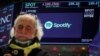 A screen displays the logo and trading information for Spotify as a trader works on the floor at the New York Stock Exchange (NYSE) in New York City, Dec. 4, 2023.