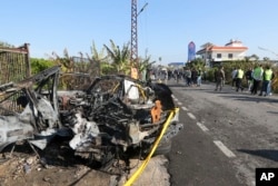 FILE - Soldiers and civil defense workers gather near a car damaged in Bazouriyeh, Lebanon, Jan. 20, 2024. An Israeli drone strike on the car, near the Lebanese port city of Tyre, killed two people, the state-run National News Agency reported.