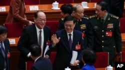 Hong Kong Chief Executive Johnnie Lee (centre) waves to delegates after the opening of the National People's Congress at the Great Hall of the People in Beijing on March 5, 2024.