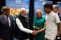 La primera dama Jill Biden y el primer ministro indio Narendra Modi saludan a Noah Isirimah durante su visita a la Fundación Nacional de Ciencias en Alexandria, Virginia, el 21 de junio de 2023.