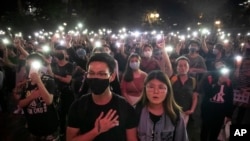 FILE - Demonstrators hold their cellphones aloft as they sing "Glory to Hong Kong" during a rally at Chater Garden in Hong Kong, on Oct. 26, 2019. 