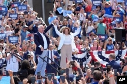 Democratic presidential nominee Vice President Kamala Harris is welcomed by Democratic vice presidential nominee Minnesota Governor Tim Walz before she speaks at a campaign event in Eau Claire, Wisconsin, Aug. 7, 2024.