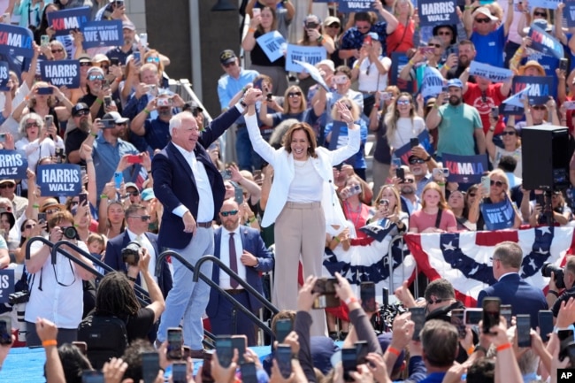 Democratic presidential nominee Vice President Kamala Harris is welcomed by Democratic vice presidential nominee Minnesota Governor Tim Walz before she speaks at a campaign event in Eau Claire, Wisconsin, Aug. 7, 2024.