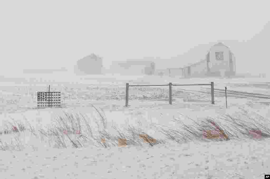 An American flag is seen fixed to a farm fence along US Highway 20 during a blizzard near Galva, Iowa, Jan. 13, 2024. 