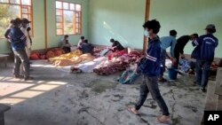 People attend to the bodies of victims of airstrikes, wrapped in blankets, at a building in Kanan village, Khampat town in Sagaing region, Myanmar, Jan.7, 2024.