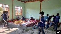 People attend to the bodies of victims of airstrikes, wrapped in blankets, at a building in Kanan village, Khampat town in Sagaing region, Myanmar, Jan.7, 2024.