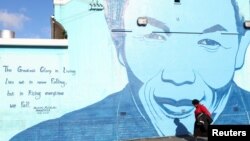 A person walks past a mural of former president Nelson Mandela as many celebrate Mandela Day that takes place on 18 July to honor the life and legacy of Nelson Mandela in Cape Town, South Africa, July 18, 2023.