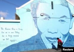 A person walks past a mural of former president Nelson Mandela as many celebrate Mandela Day that takes place on 18 July to honour the life and legacy of Nelson Mandela in Cape Town, South Africa, July 18, 2023.