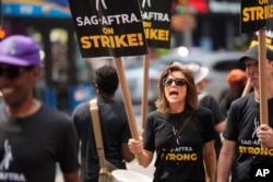 Actor Jennifer Van Dyck carries a sign on a picket line outside Paramount in Times Square in New York, July 17, 2023. The actors strike comes more than two months after screenwriters began striking in their bid to get better pay and working conditions.