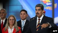 Venezuela's President Nicolas Maduro addresses the media next to his wife, Cilia Flores, after appearing before the Supreme Court of Justice in Caracas on Aug. 9, 2024.