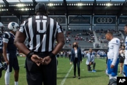 FILE - Vice President Kamala Harris takes part in the ceremonial coin toss before an NCAA college football game between Howard and Hampton in Washington, Sept. 18, 2021.