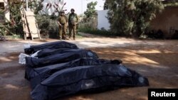 以色列士兵在以色列南部Kibbutz Kfar Aza地区守护着被巴勒斯坦武装分子杀害的以色列平民的遗体。（2023年10月10日）