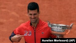 Serbia's Novak Djokovic holds the trophy after winning the men's singles final match of the French Open tennis tournament against Norway's Casper Ruud in three sets, 7-6, (7-1), 6-3, 7-5, at the Roland Garros stadium in Paris, Sunday, June 11, 2023. (AP Photo/Aurelien Morissard)