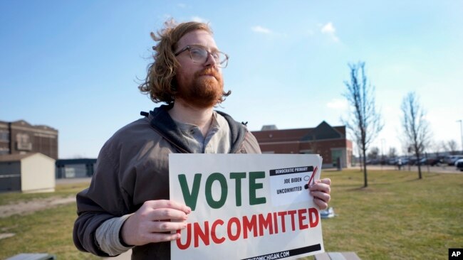 미국 미시간주 유권자 27일 예비선거 투표장 앞에서 '지지 후보 없음' 사인을 들고 있다.