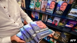 Seorang pria membawa salinan buku 'The Conspiracy' yang ditulis oleh presiden terguling Sri Lanka Gotabaya Rajapaksa di sebuah toko buku di Kolombo, 7 Maret 2024. (Ishara S.KODIKARA/AFP)