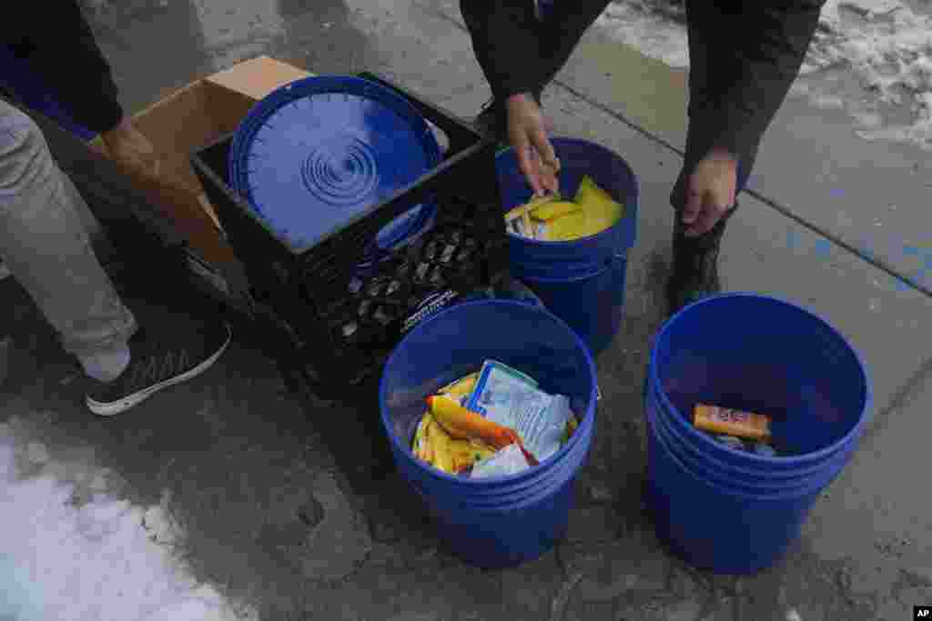 El Pastor Jonathan de la O, de la Iglesia Comunitaria Starting Point, y voluntarios distribuyen suministros sanitarios, ropa y sánguches a migrantes en la calle.