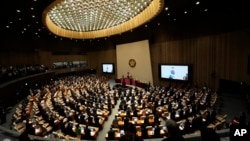 South Korean lawmakers salute their national flag during the opening session of the 22nd National Assembly in Seoul, South Korea, Sept. 2, 2024.