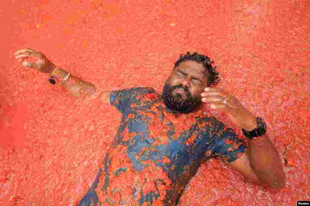 Participante deitado em polpa de tomate no festival anual de luta de comida &ldquo;La Tomatina&rdquo; em Bunol, perto de Valência, Espanha, 28 de agosto de 2024. &nbsp; 