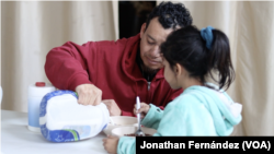 Un migrante venezolano sirve leche en el cereal de su pequeña hija en el albergue el Buen Samaritano de Ciudad Juárez, México, el 24 de enero de 2024.