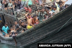 Pengungsi Rohingya yang baru tiba terdampar di perahu karena masyarakat sekitar memutuskan untuk tidak mengizinkan mereka mendarat setelah memberikan air dan makanan di Pineung, Aceh, 16 November 2023. (Foto: AMANDA JUFRIAN/AFP)