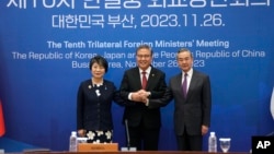 Dari kiri: Menlu Jepang Yoko Kamikawa, Menlu Korea Selatan Park Jin, dan Menlu China Wang Yi berfoto sebelum pertemuan para menteri luar negeri trilateral di Busan, Korea Selatan hari Minggu 26 November 2023.