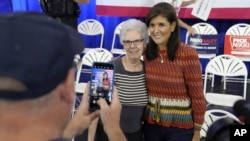 FILE - Republican presidential candidate Nikki Haley takes a photo with a prospective caucusgoer after a campaign event, Sept. 30, 2023, in Clive, Iowa.