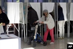 A woman emerges from a voting booth at a polling station in Taipei, Taiwan, January 13, 2024. (Photo: AP)