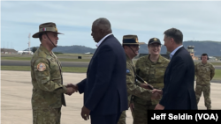 U.S. Secretary of Defense Lloyd Austin, second from left, and Australian Defense Minister Richard Marles, far right, greet uniformed military officials in Townsville, Australia.