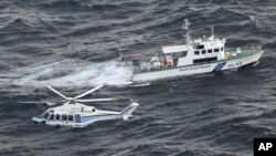 Helikopter penjaga pantai dan kapal patroli Jepang melakukan operasi pencarian dan penyelamatan di perairan tempat pesawat militer AS Osprey jatuh di lepas pantai Pulau Yakushima, prefektur Kagoshima, Jepang selatan, 30 November 2023. (Foto: Kyodo via AP)