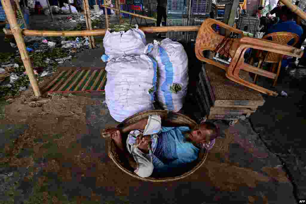 A man takes a nap on his basket at a wholesale market in Dhaka, Bangladesh. 