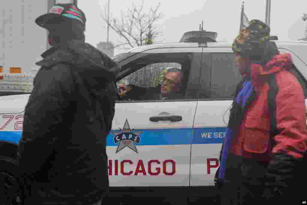 Citando preocupaciones de seguridad acerca de los migrantes cruzando la calle en medio del tráfico, un oficial de policía de Chicago instruye al Pastor Jonathan de la Iglesia Comunitaria Starting Point para que indique a las personas que se reúnan con él más adelante.