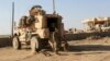 FILE - In this Feb. 23, 2017 file photo, U.S. Army soldiers stand outside their armored vehicle on a joint base with the Iraqi army, south of Mosul, Iraq.