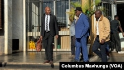 Attorney Alec Muchadehama, black suit, and Tendai Biti, blue suit, leave the Harare court on Feb. 27, 2024. 