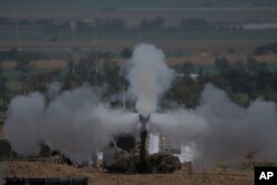 An Israeli mobile artillery unit fires a shell from southern Israel towards the Gaza Strip, in a position near the Israel-Gaza border, Jan. 14, 2024.