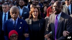 From left, the Rev. Al Sharpton, Vice President Kamala Harris and Attorney Ben Crump sing as they and others walk across the Edmund Pettus Bridge, marking the 59th anniversary of the 1965 Bloody Sunday voting rights march in Selma, Alabama, March 3, 2024.