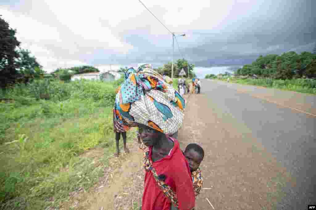 Pessoas deslocadas da província de Cabo Delgado caminham pelas ruas de Namapa, distrito de Erati, em Nampula, Moçambique, a 27 de fevereiro de 2024.